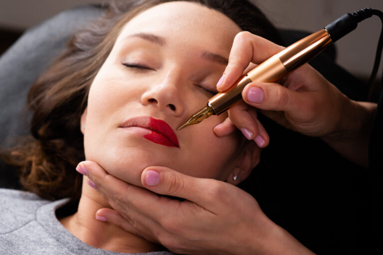Young woman making lips tatouage in a dressing makeup room